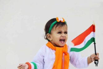 girl in white and green long sleeve shirt with orange and white scarf